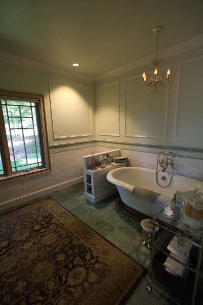 Tiled bathroom with painted walls and bathtub.