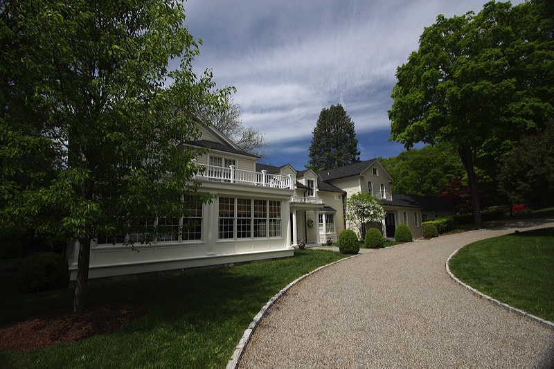 Driveway leading to the painted house exterior.